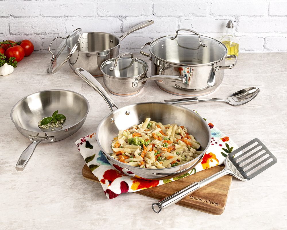 Country Living stainless steel cookware set with a skillet of vegetables and rice on a wooden board