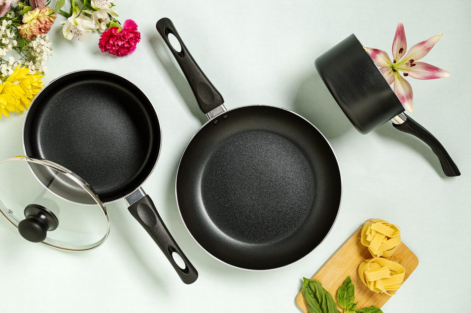 Ecolution Easy Clean fry pans, square grill pan and glass lid styled with flowers and linen